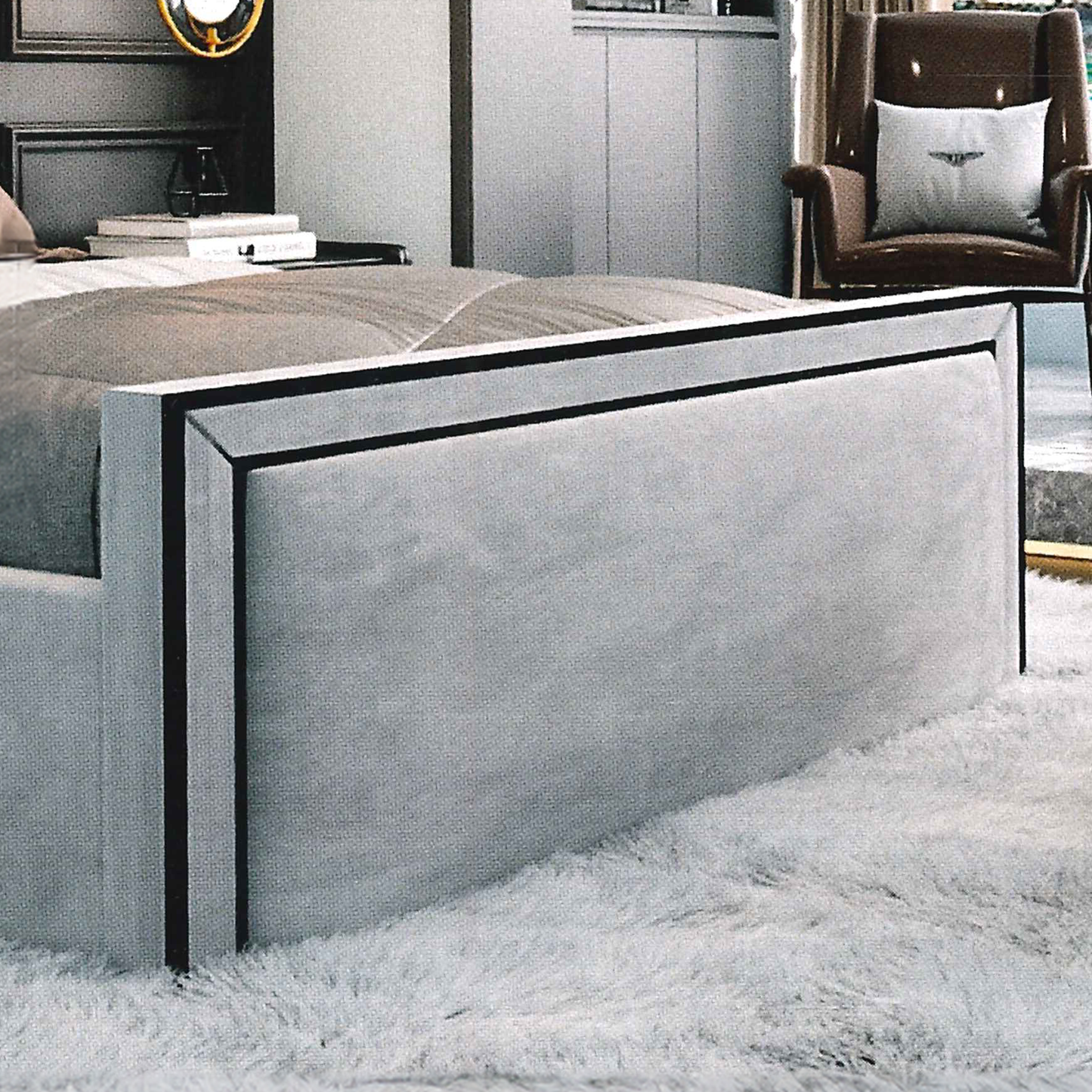 Modern bedroom with a gray upholstered bed and brown chair.