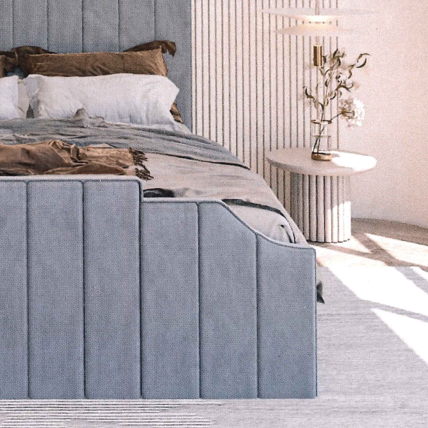 Modern bedroom with a gray upholstered bed footboard and decorative pillows.