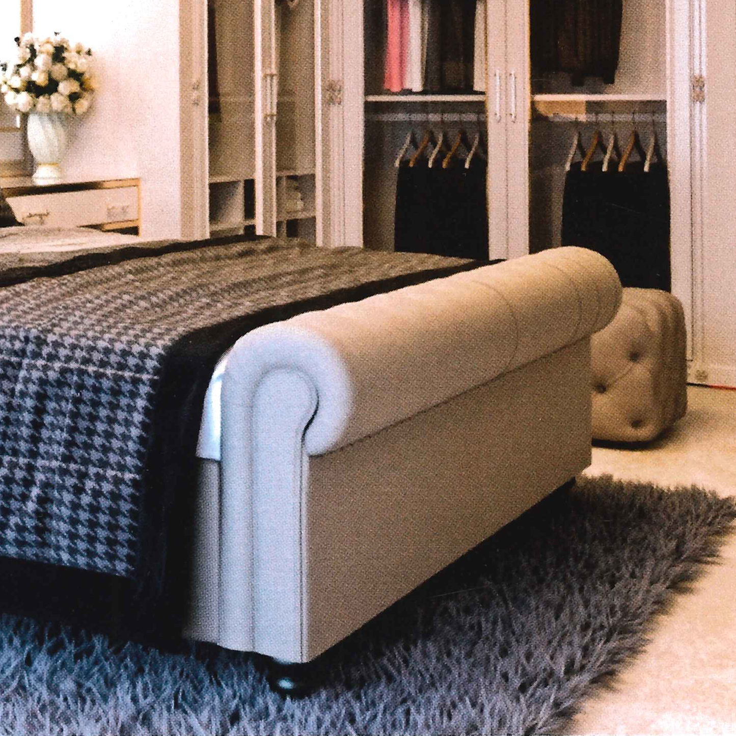 Ottoman bed in a bedroom setting with a bed and wardrobe in the background.