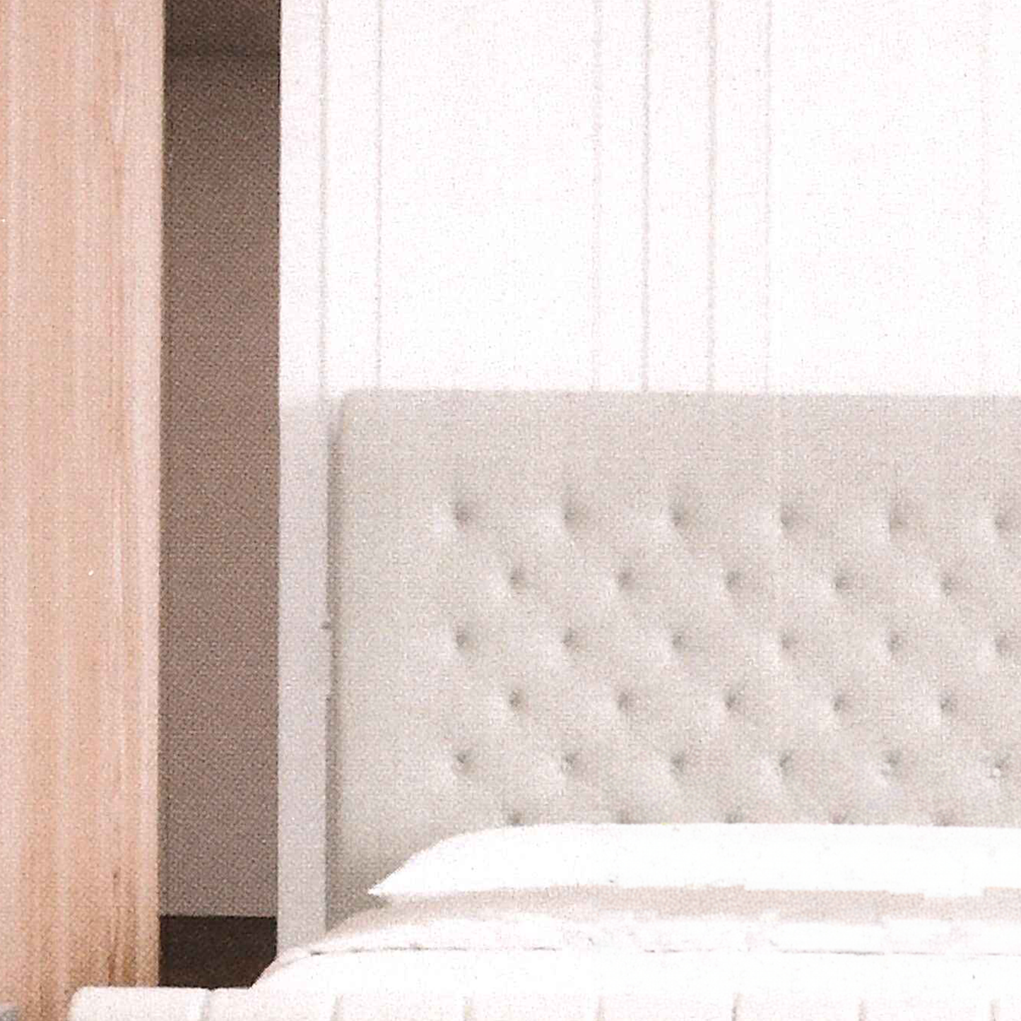 Close-up of a tufted headboard in a bedroom setting