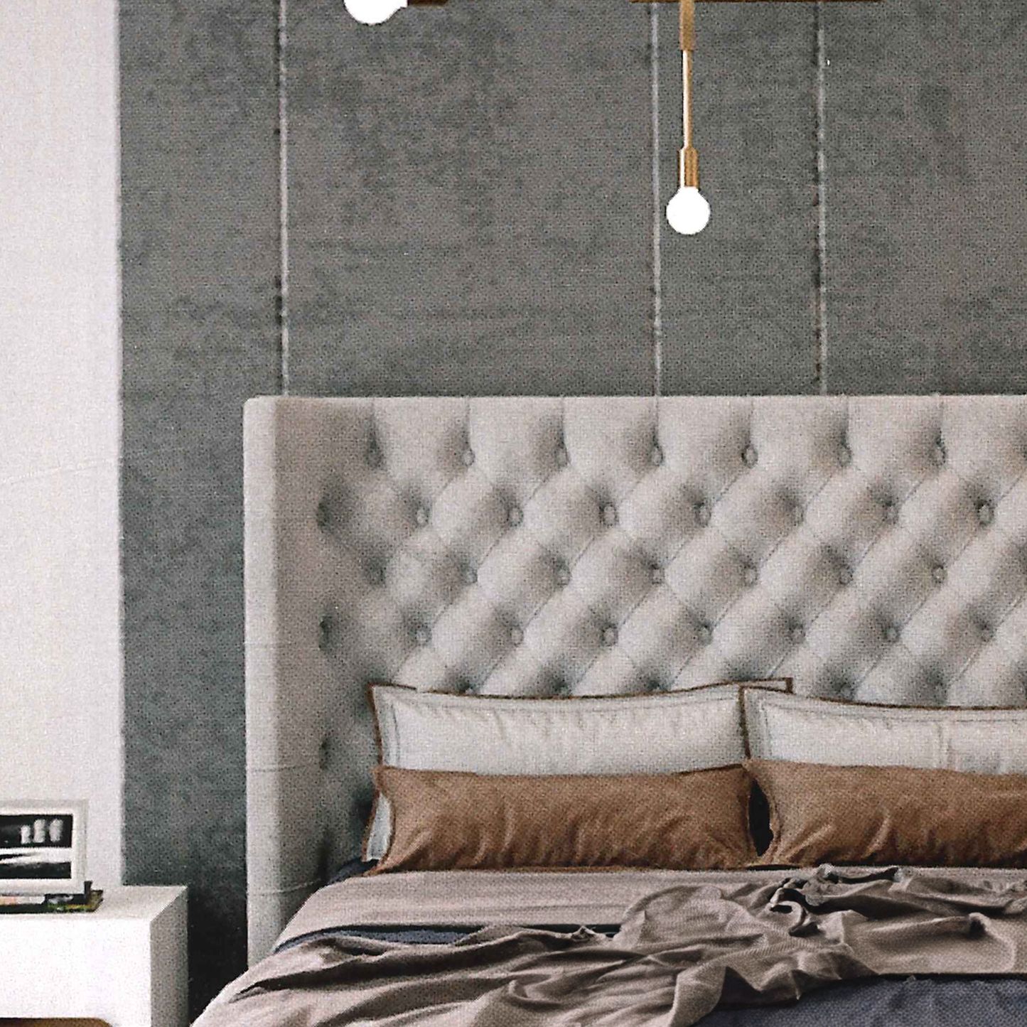 Bedroom with a tufted headboard and decorative pillows against a gray wall.