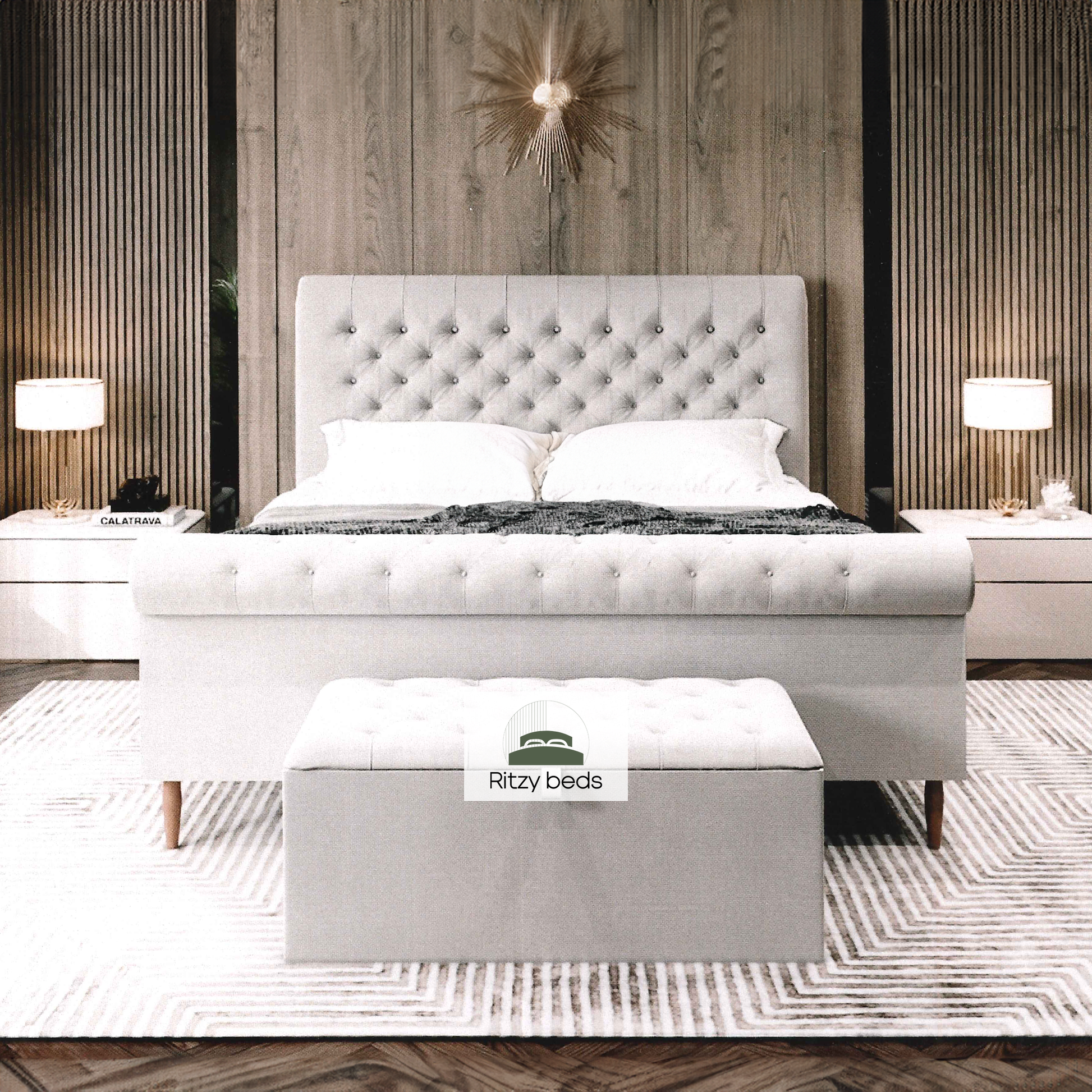 Gray upholstered handmade bed with buttoned tufted scrool headboard and footboard in a bedroom setting, featuring 'Ritzy Beds' branding.