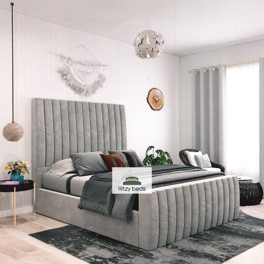 Gray upholstered bed in a modern bedroom with 'Ritzy Beds' branding.