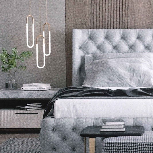 Modern bedroom with gray buttoned tufted bed and decorative pendant lights.