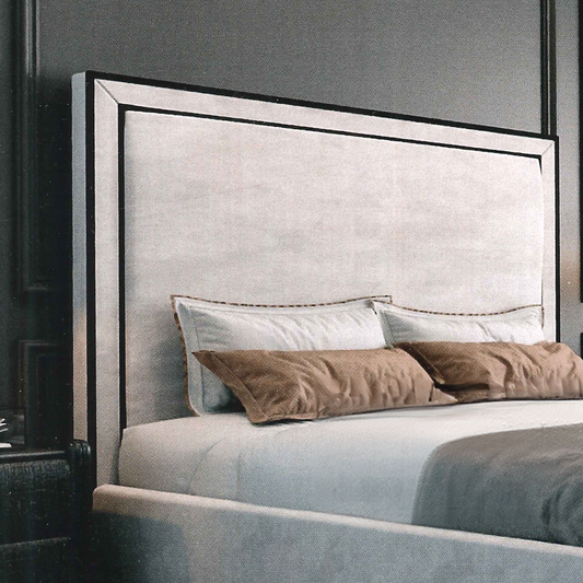 Gray upholstered headboard with decorative pillows on a bed