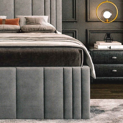 Gray luxury upholstered bed with matching footboard in a bedroom setting.