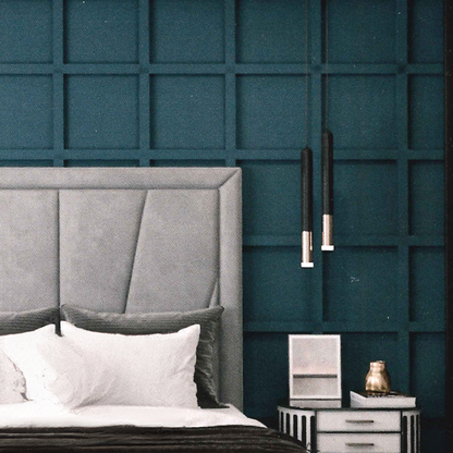 Gray geometric british upholstered headboard against a teal paneled wall with a nightstand.