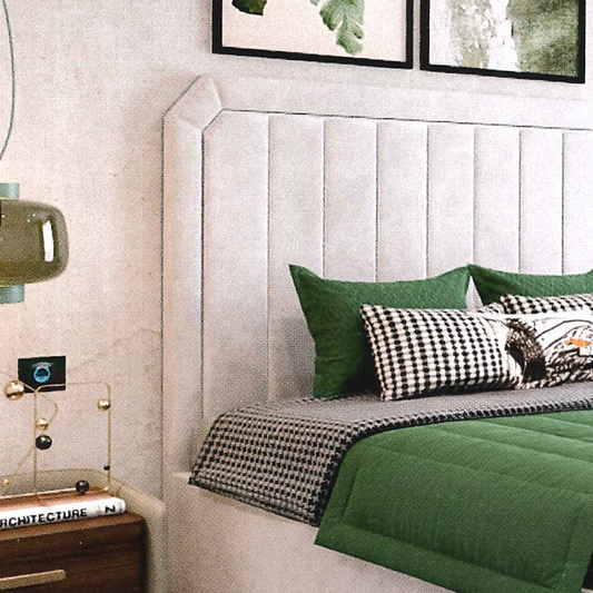 Bedroom with green bedding and decorative pillows on a upholstered luxury bed with a textured headboard.