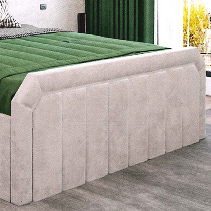 beige upholstered headboard with green mattress on a bed in a room with a window and plant.