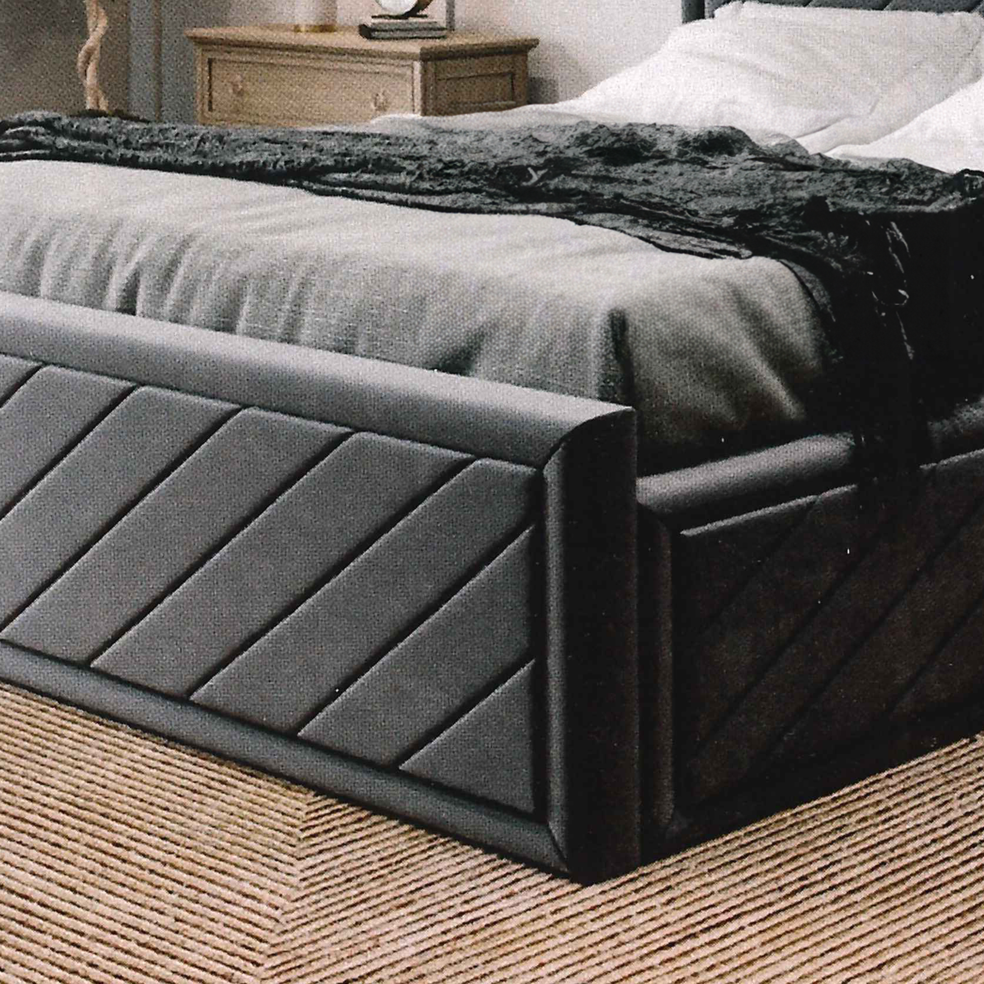 Dark gray upholstered british bed with textured headboard in a bedroom setting