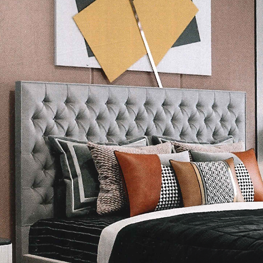 Gray luxury tufted headboard with decorative pillows against a wall with abstract art.