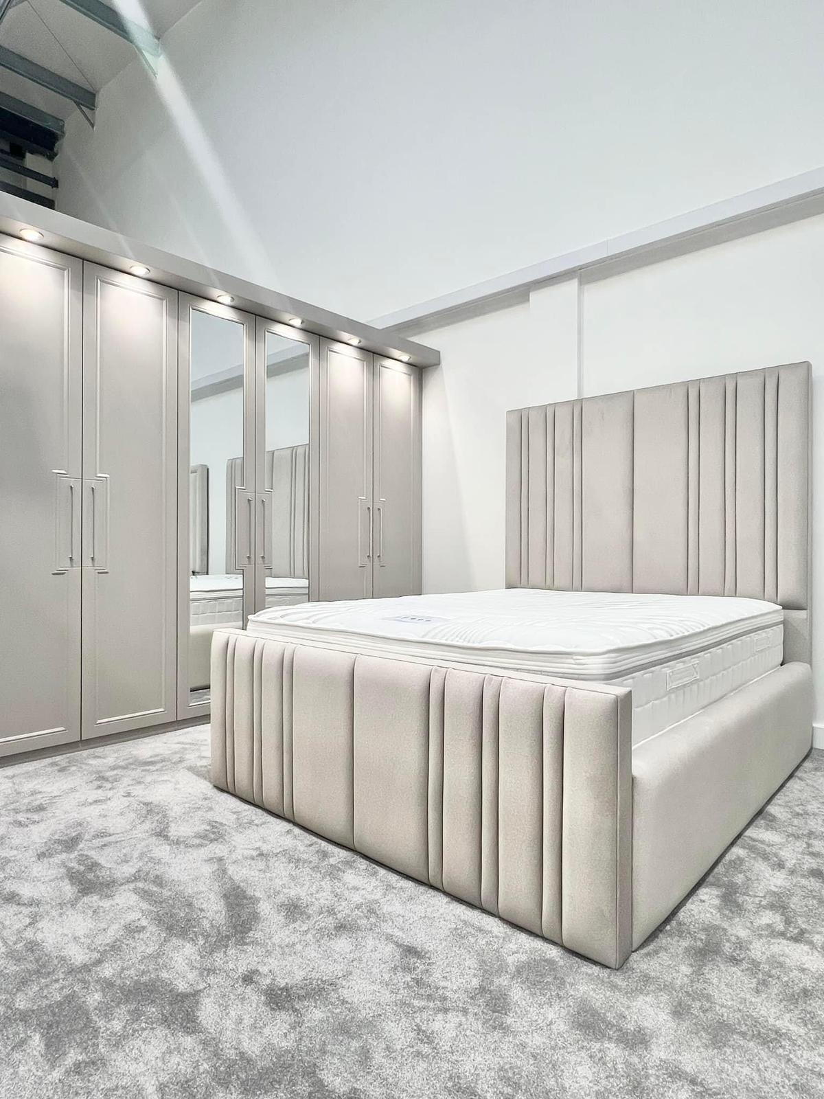 Modern bedroom with a tufted bed and wardrobe in a neutral color scheme.