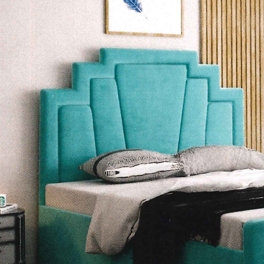 Turquoise upholstered headboard with decorative pillows on a bed in a bedroom setting.