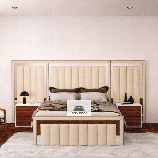 Beige upholstered bed with wooden side tables in a bedroom setting, featuring the brand 'Ritzy Beds'.
