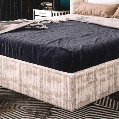 Bed with dark blue mattress cover and beige bed frame in a bedroom setting.